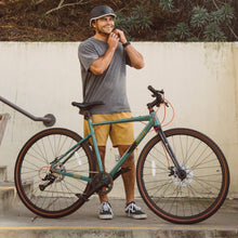 Load image into Gallery viewer, Rider standing beside the Grateful Dead Amok gravel bike